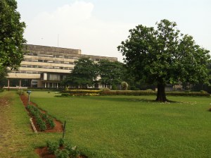 The main building seen across the lawn in front of the ocean.